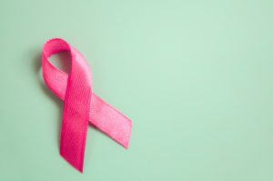 pink-breast-cancer-ribbon-on-green-background