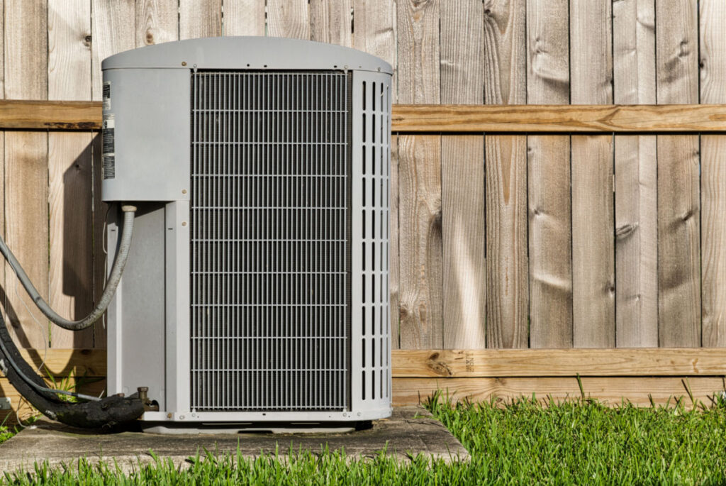 newly installed HVAC system in front of a wood fence