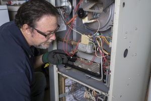 technician-working-on-wiring-in-furnace