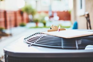 outdoor-ac-unit-with-clipboard-and-paper-resting-on-top