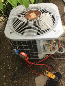 outside-ac-unit-with-rust-on-top-and-meter-attached-to-test-it