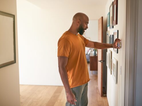 Man Adjusting a Smart Thermostat At Home